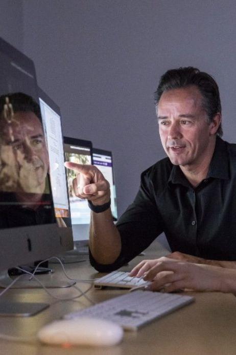 Mike Nawrocki在电脑前帮助电影专业的学生